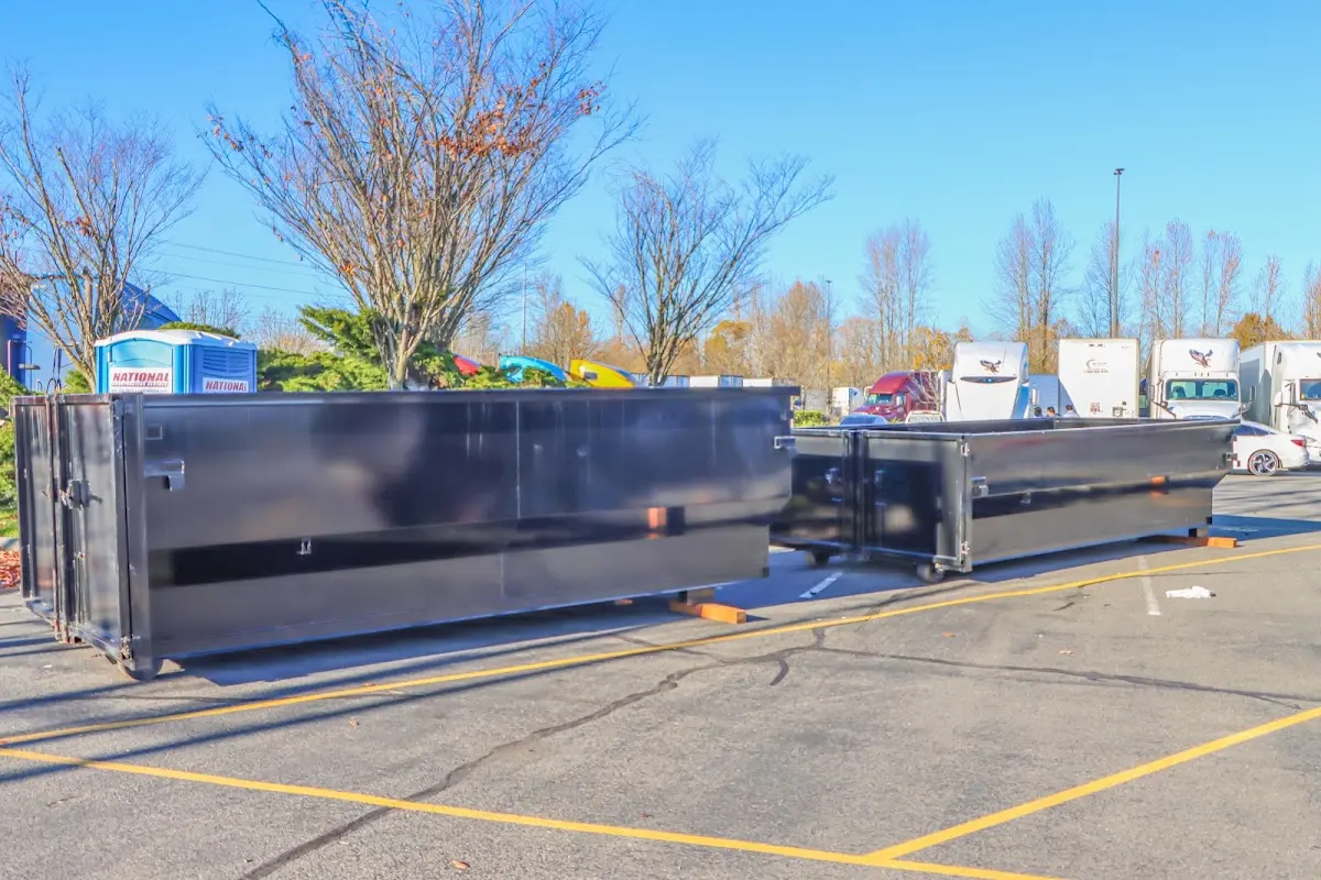 Professional dumpster rental service with roll-off container on residential driveway in Enterprise